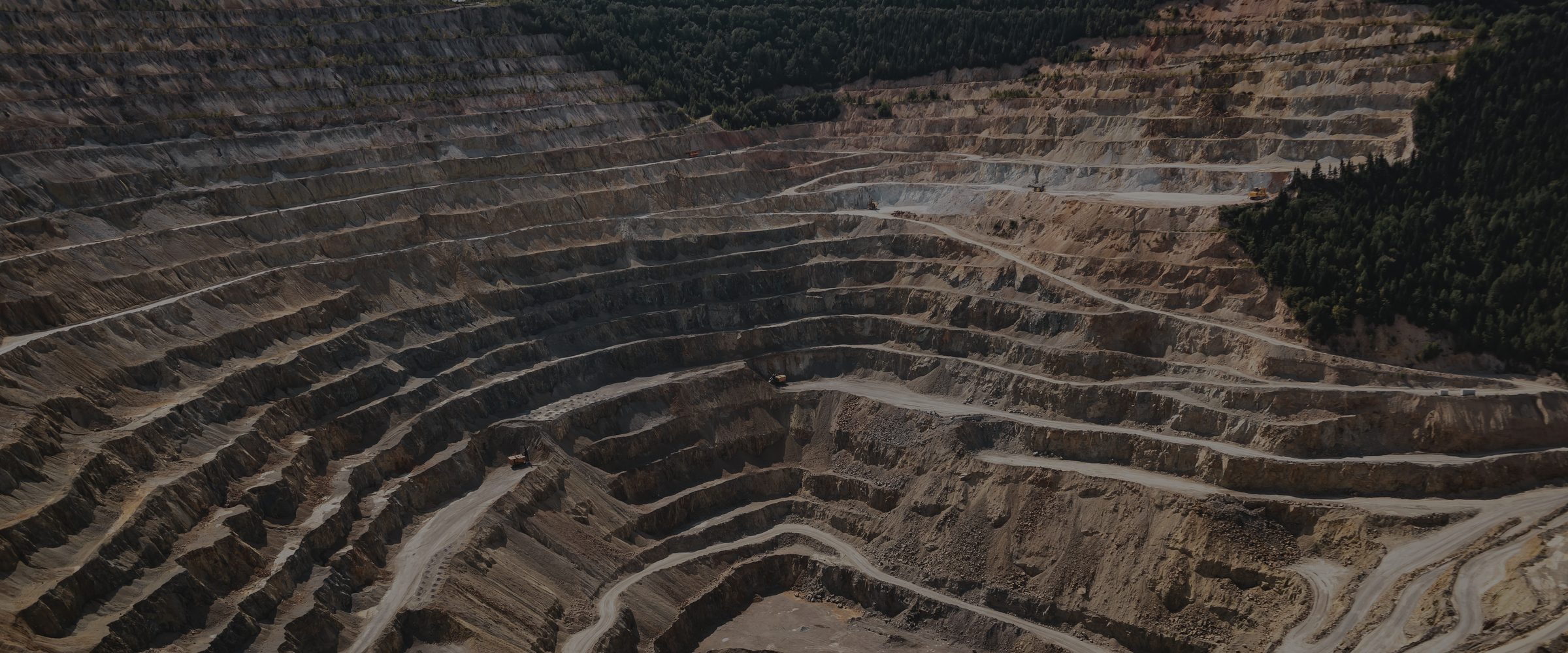 Aerial view of an open pit mine with benches stepping down to the pit floor